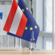Test tubes and medication bottles in front of the Austrian and the EU flag