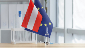 Test tubes and medication bottles in front of the Austrian and the EU flag