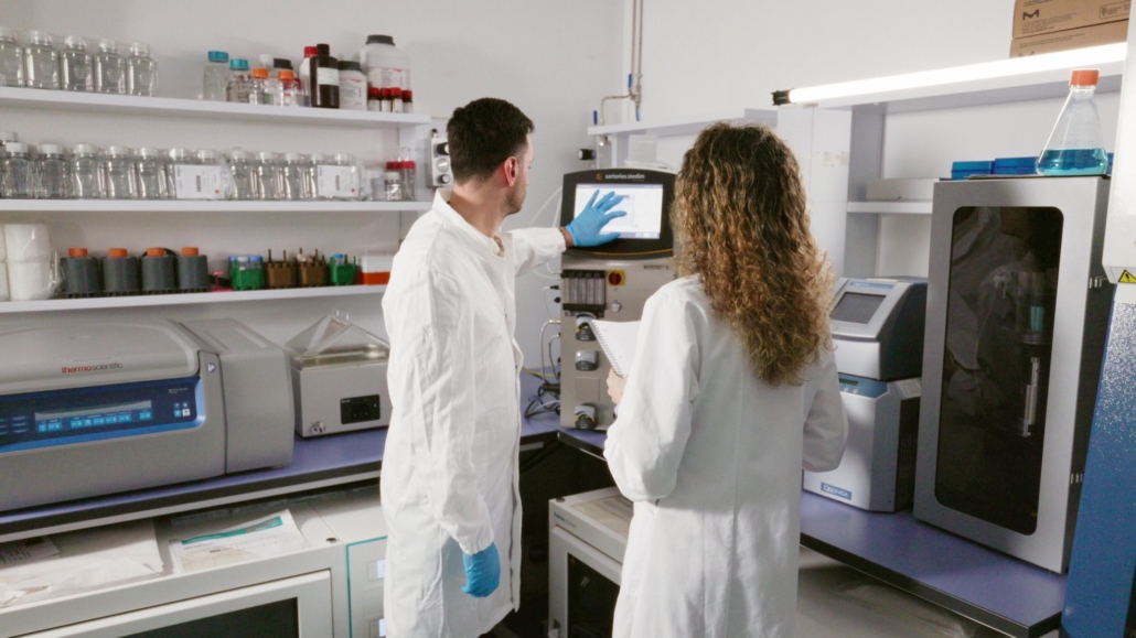 Nouscom employees in front of chromatography machine for purification of its viral vector based products.