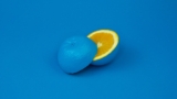 A blue orange sliced into two halves with aesthetic blue background