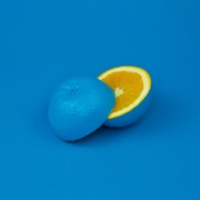 A blue orange sliced into two halves with aesthetic blue background